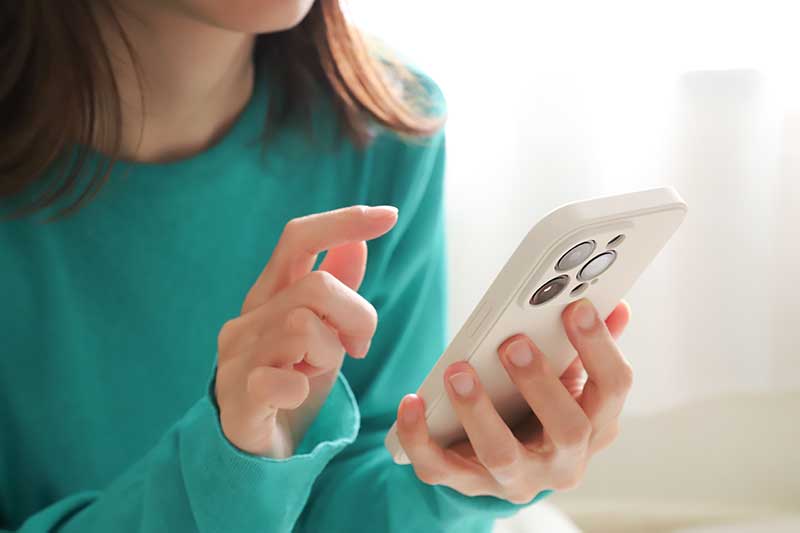 Junge Frau schaut auf einem Smartphone nach Terminen